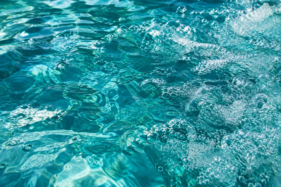Close view of ripples and bubbles in bright aqua hot tub water